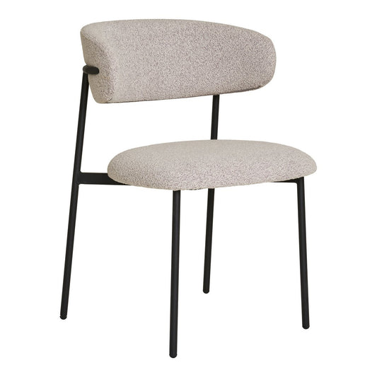 Set van twee House Nordic Mira eetkamerstoelen in zandkleurige bouclé stof met zwarte metalen poten, staand aan een eettafel in een modern interieur.