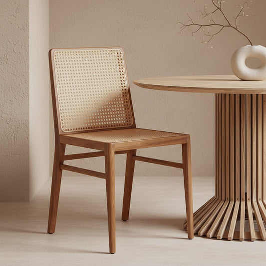 Raw Materials Nova eetkamerstoel naturel, gemaakt van duurzaam teakhout met een handgeweven rotan zitting en rugleuning, staand in een modern interieur